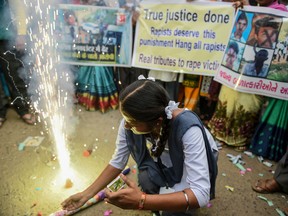 A schoolgirl  in Ahmedabad celebrates with firecrackers after police shot dead four detained gang-rape and murder suspects near Hyderabad on December 6, 2019.
