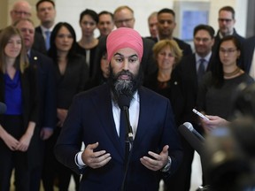 NDP leader Jagmeet Singh stands in front of his caucus as he speaks to reporters after the weekly caucus meeting in Ottawa on Wednesday, Dec. 4, 2019.