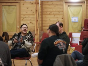 RRyan Beardy, former gang member and Healing Together founder, holds an eagle feather as he speaks during a meeting of Healing Together in Thunderbird House in downtown Winnipeg, Sunday, Dec. 8, 2019. Beardy, 35, who spent 20 years in and out of the justice system, formed the group to make a place where men can feel safe to share their feelings and support each other towards a healthier life. Many of the men discuss how they previously took part in adverse lifestyles like gangs and drugs. Now, Beardy says, they discuss how to be better men, fathers and community members.