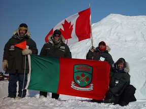 Ranger Shane Oakley from Haines Junction, Yukon, Canadian Ranger Commanding Officer Maj. Yves Laroche, Ranger Debbie Iqaluk from Resolute Bay, Nunavut, and Ranger Cpl. Adam Alogut from Chesterfield Inlet hold up the Ranger flag at the Magnetic North Pole in a file photo from 2002.