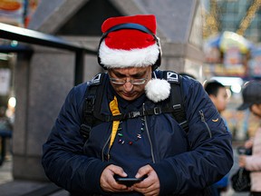 A man checks his cellphone on 6th Avenue in New York City on Dec. 23, 2019.