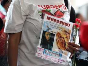 A woman holds a sign during the closing ceremony of the National Inquiry into Missing and Murdered Indigenous Women and Girls in Gatineau, Quebec, June 3, 2019.