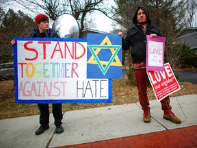 People hold signs of support near the house of Rabbi Chaim Rottenberg on Dec. 29, 2019, in Monsey, N.Y. Five people were stabbed in a Dec. 28 attack on Hanakkah celebrants at the rabbi's home, which adjoins a synagogue. Authorities have deemed it a case of domestic terrorism.