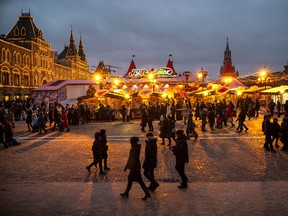 People walk at Holiday's Market on Red Square, decorated for New Year and Orthodox Christmas celebrations in Moscow, Russia, Dec. 30, 2019.