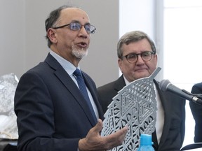 Quebec Islamic cultural centre president Boufeldja Benabdallah, left, and Quebec City mayor Regis Labeaume hold one of the six metal leafs representing one of the six victims of the 2017 Mosque shooting, Tuesday, January 29, 2019 in Quebec City. Quebec City's mayor has signed a deed of sale for a parcel of land that will soon become the region's first Muslim cemetery.