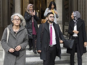 Members of the National Council of Muslims Mustafa Farooq, centre, and Bochra Manai, left, alongside supporters leave the Quebec Court of Appeal in Montreal, Tuesday, Nov. 26, 2019, where they challenged Quebec's Bill 21.