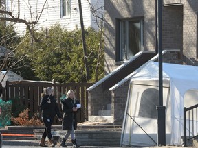 Police canvas the area outside a home after the discovery of three bodies in an east-end Montreal, Wednesday, Dec.11, 2019. Police say the bodies of a woman, 42, and two boys, ages 4 and 2, were found today in Montreal's Pointe-aux-Trembles district.