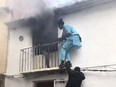 Neighbours save a man from a burning apartment in Denia, Spain December 6, 2019 in this picture obtained from social media. Picture taken December 6, 2019.