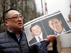 Louis Huang holds a sign calling for China to release Canadian detainees Michael Spavor and Michael Kovrig outside a court hearing for Huawei Technologies Chief Financial Officer Meng Wanzhou at the B.C. Supreme Court in Vancouver on March 6, 2019.