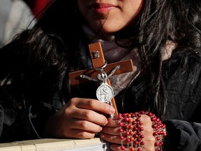 A woman holds a cross during the weekly general audience held by Pope Francis in Saint Peter's Square at the Vatican, on Dec. 4, 2019. Without missionaries the Christian faith would wither and die, writes Father Raymond J. de Souza.