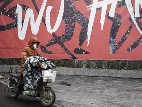 A woman wears a mask while riding an electric bicycle on January 22, 2020 in Wuhan, Hubei province, China.