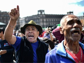 Supporters of Mexican President Andres Manuel Lopez Obrador shout slogans at people participating in a march for peace in Mexico City, on January 26, 2020. - The march for peace, led by Mexican poet and activist Javier Sicilia and Mormon activist Julian LeBaron, reached the National Palace at Zocalo square to demand the government to modify its anti-crime strategy amid the wave of violent crimes that shakes Mexico.