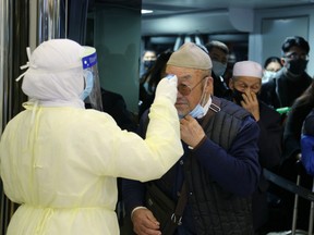 Passengers coming from China wearing masks to prevent a new coronavirus are checked by Saudi Health Ministry employees upon their arrival at King Khalid International Airport, in Riyadh, Saudi Arabia January 29, 2020.