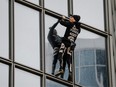 French skyscraper climber Alain Robert, popularly known as the "French Spiderman," climbs the Total tower in the west of Paris's business district of La Defense on January 13, 2020 as a symbolic action to support on strike workers on the 40th day of a nationwide movement against a French government pension reform.