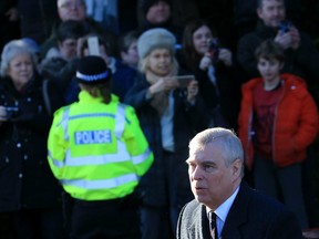 A police officer stands with wellwishers as Britain's Prince Andrew, Duke of York, arrives to attend a church service at St Mary the Virgin Church in Hillington, Norfolk, eastern England, on January 19, 2020.