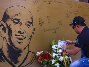 A fan places flowers to mourn former Los Angeles Lakers basketball player Kobe Bryant following his death overnight in the US, near the "House of Kobe" gym built in honour of his 2016 visit to the Philippines, in Manila on January 27, 2020.