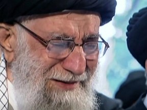An image grab from an Iran Press video shows Iranian Supreme Leader Ayatollah Ali Khamenei weeping as he recites a prayer in front of the coffin of slain Iranian military commander Qasem Soleimani duing a funeral procession in the capital Tehran on Jan. 6, 2020.