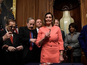 Speaker of the House Nancy Pelosi holds a pen used for signing the articles of impeachment of US President Donald Trump during an engrossment ceremony on Capitol Hill January 15, 2020, in Washington, DC.