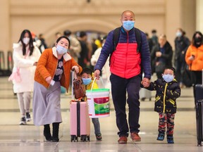 Commuters wearing face masks walk in Hankou railway station in Wuhan, in China's central Hubei province on January 21, 2020. - Asian countries on January 21 ramped up measures to block the spread of a new virus as the death toll in China rose to six and the number of cases surpassed 300, raising concerns in the middle of a major holiday travel rush.