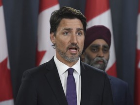 Prime Minister Justin Trudeau holds a news conference updating the Iran plane crash in Ottawa on Thursday, Jan. 9, 2020, as Defence Minister Harjit Sajjan looks on.