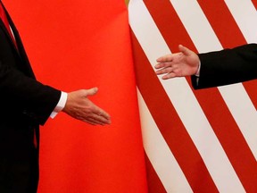 U.S. President Donald Trump and China's President Xi Jinping move to shake hands in Beijing in November, 2017. The Phase 1 trade agreement to be signed today caps 18 months of tariff conflict between the world's two largest economies that has hit hundreds of billions of dollars in goods, roiling financial markets, uprooting supply chains and slowing global growth.