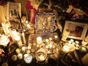 Photographs are left among candles at a memorial during a vigil in Toronto on Thursday, January 9, 2020, to remember the victims of the Iranian air crash.