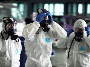 Members of a Thai Airways crew prepare to disinfect the cabin of an aircraft to prevent the spread of the coronavirus.