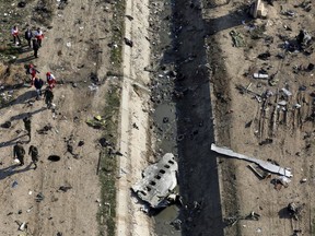 Rescue workers search the scene where a Ukrainian plane crashed in Shahedshahr, southwest of the capital Tehran, Iran on Wednesday, Jan. 8, 2020. Iran needs technical assistance from France and the United States to analyze data from the Ukrainian jetliner that was accidentally shot down, says a preliminary report released by the country's National Aviation Authority on Monday.