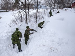 Soldiers from the 4th Artillery Regiment based at CFB Gagetown clear snow at a residence in St. John's on Monday, January 20, 2020.