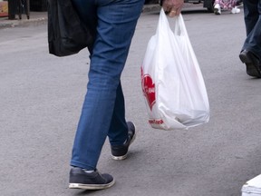 A woman carries a plastic bag at a market in Montreal on June 13, 2019. The mayor of Victoria says she's disappointed Canada's highest court won't reconsider a lower court ruling that stopped her city from regulating single-use plastic bags, but Lisa Helps says there are other ways to eliminate the items.