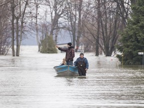 A man pulls people along a flooded residential street in a boat in Rigaud, Que, west of Montreal, Friday, April 26, 2019. Ottawa's bills for dealing with natural disasters neared half a billion dollars in two of the last three years.