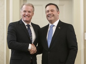 Alberta Premier Jason Kenney shakes hands with Grant Hunter, Associate Minister of Red Tape Reduction, after being sworn into office in Edmonton. Kenney says it's possible the province could close or relocate safe drug injection sites.