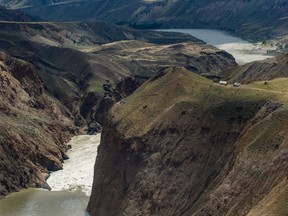 Workers are seen on the cliff at the site of a massive rock slide on the Fraser River near Big Bar, west of Clinton, B.C., on Wednesday July 24, 2019. Federal Fisheries Minister Bernadette Jordan says construction will begin soon to help salmon pass through a section of British Columbia's Fraser River that was largely closed by a landslide.