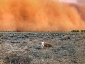 A child runs towards a dust storm in Mullengudgery in New South Wales on Jan. 17.