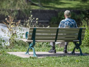 An elderly man sits on a bench while looking at the Humber River in Toronto, Thursday August 29, 2019.