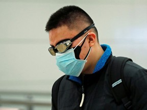 A passenger wears a face mask and swim goggles as he arrives at the Hong Kong train station on January 29, 2020.