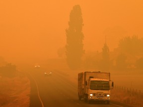 Residents commute on a road through thick smoke from bushfires in Bemboka, in Australia's New South Wales state on January 5, 2020. - Australians on January 5 counted the cost from a day of catastrophic bushfires that caused "extensive damage" across swathes of the country and took the death toll from the long-running crisis to 24.