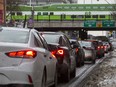 A GO train passes above vehicles lined up to access the Gardiner Expressway during the evening rush hour in downtown Toronto on Jan. 22, 2019.