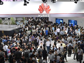 This file photo taken on June 26, 2019 shows people visiting a Huawei stand during the Mobile World Congress (MWC 2019) introducing next-generation technology at the Shanghai New International Expo Centre (SNIEC) in Shanghai.