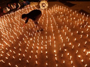 A protester lights candles during a candlelight vigil to mark the first anniversary of the Delhi gang rape, in New Delhi December 16, 2013.