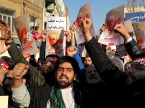 Hardline protesters chant slogans while holding up posters of Gen. Qassem Soleimani in front of British Embassy in Tehran, Iran, Sunday, Jan. 12, 2020.