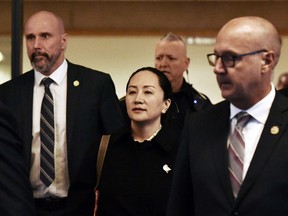 Huawei CFO Meng Wanzhou leaves British Columbia Supreme Court with her security detail on Jan. 23, 2020 in Vancouver.