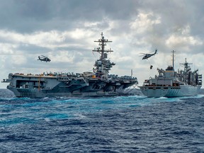 Nimitz-class aircraft carrier USS Abraham Lincoln conducts a replenishment-at-sea with the fast combat support ship USNS Arctic, while MH-60S Sea Hawk helicopters  transfer stores between the ships, in a photo released by the U.S. Navy on May 8, 2019.