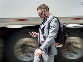A man using a cellphone in Toronto.
