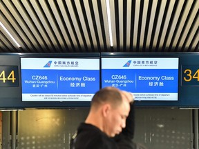 A passenger waits to check in by the counter of China Southern Airlines at Rome's Fiumicino airport for a flight returning to Wuhan, China, after it landed early on January 23, 2020.