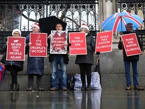 Brexit supporters hold signs outside the Houses of Parliament in London, England, on Dec. 20, 2019. Brexit is an example of liberal democracy dealing with a fundamental disagreement in a country and doing so peacefully, writes Michael Ignatieff.