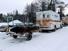 Quebec provincial police vehicles are seen in St-Henri-de-Taillon, Que. on Wednesday, January 22, 2020. One person is dead and five tourists from France are missing after a group of snowmobilers plunged through the ice Tuesday night near Quebec's Lac-Saint-Jean.