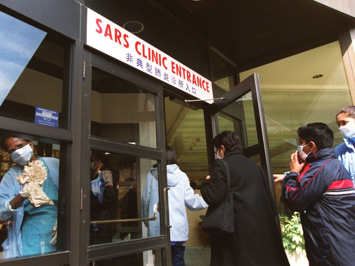  A hospital worker disinfects the entrance to Toronto Women’s College Hospital’s SARS clinic as patients arrive to be tested.
