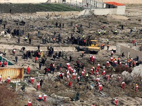 Rescue workers search the scene where an Ukrainian plane crashed in Shahedshahr, southwest of the capital Tehran, Iran, Wednesday, Jan. 8, 2020. A Ukrainian passenger jet carrying 176 people crashed on Wednesday, just minutes after taking off from the Iranian capital's main airport, turning farmland on the outskirts of Tehran into fields of flaming debris and killing all on board.