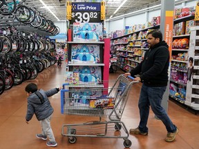 A boy and his father walk through the toy section of a Walmart in King of Prussia, Penn., on Black Friday, Nov. 29, 2019.